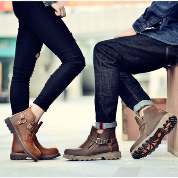 Un homme et une femme posent dans la rue. Il porte des vêtements en jean et des bottins basses imperméables camel pour la femme et marron pour l'homme. 
